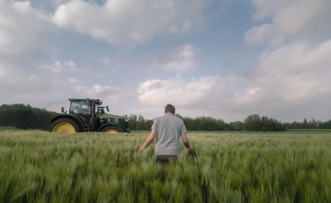 Farmer walking in a grassland field 