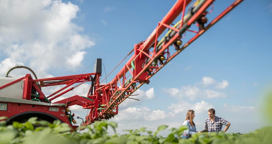 Farmer and a Yara Agronomist in a field with a spreader