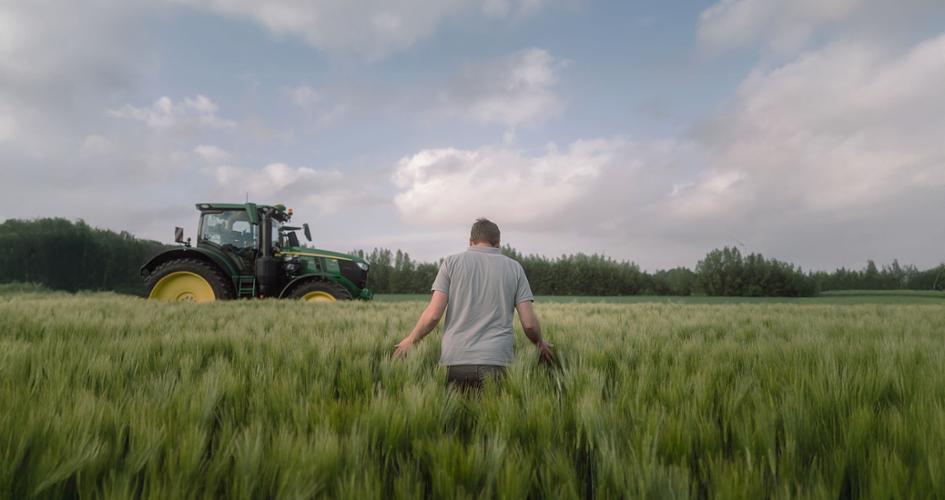Farmer walking in a grassland field 