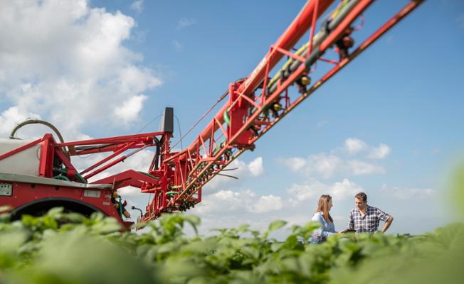 Farmer and a Yara Agronomist in a field with a spreader